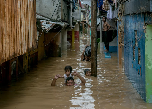 Pai tenta salvar criança em inundação na Indonésia. (Fonte: Ares Jonekson/Shutterstock/Reprodução)
