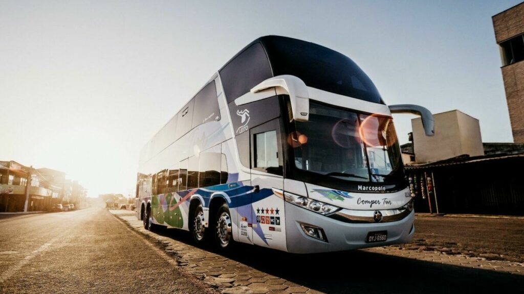 imagem de um ônibus de viagem em uma estrada asfaltada